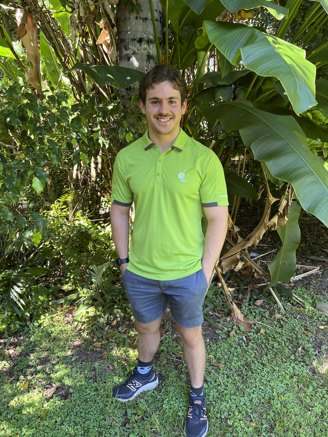 A picture of Joseph Fernandez-Andes in a green collared shirt and grey shorts with trees in the background.